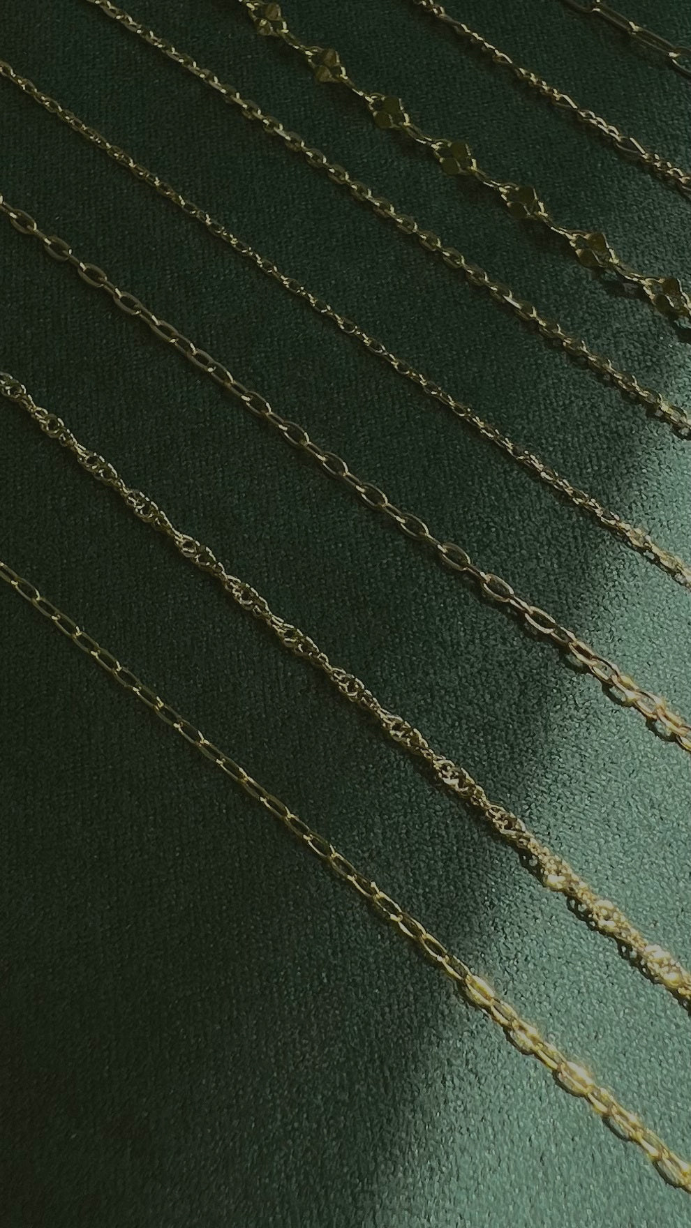 gold chains on dark green velvet backdrop